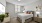 Studio Apartments In Downtown Jacksonville, FL - The Strand - Bedroom with Carpeted Flooring, Large Bed, Nightstands with Lamps, Dresser, TV, Soft Grey Walls, Wall Art, and Window with Blinds